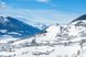 Ein verschneites Bergdorf inmitten einer winterlichen Alpenlandschaft