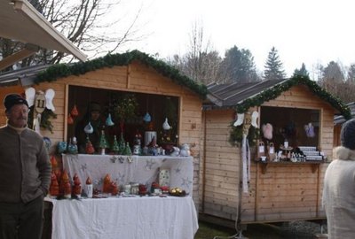 Zwei festlich dekorierte Adventmarktstände im Schloss Lockenhaus bieten kunsthandwerkliche Weihnachtsartikel und handgefertigte Dekorationen in traditioneller Atmosphäre an