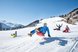 Menschen rodeln auf einer verschneiten Piste