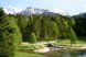 Parklandschaft mit Teich vor einer beeindruckenden Bergkulisse