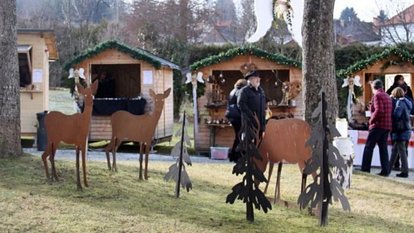 Adventlich geschmückte Marktstände und rustikale Holzfiguren sorgen im Schloss Lockenhaus für stimmungsvolle Weihnachtsmarkt-Atmosphäre