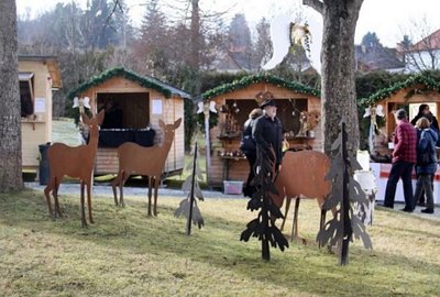 Adventlich geschmückte Marktstände und rustikale Holzfiguren sorgen im Schloss Lockenhaus für stimmungsvolle Weihnachtsmarkt-Atmosphäre