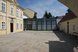 Innenhof eines historischen Gebäudekomplexes mit moderner Glasfassade und gepflastertem Vorplatz