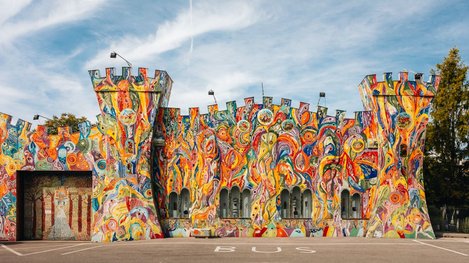 Bunt gestaltetes Gebäude mit einer farbenfrohen, fantasievollen Fassadenkunst aus zahlreichen abstrakten Formen und Figuren