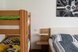 Gemütliches Schlafzimmer mit Doppelbett, Stockbett und heller, freundlicher Einrichtung aus Holz