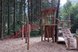 Großer Abenteuerspielplatz aus Holz im Wald mit Kletter- und Rutschelementen