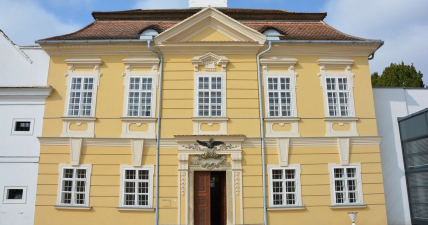 Historisches Gebäude mit heller Fassade und repräsentativem Eingangsportal