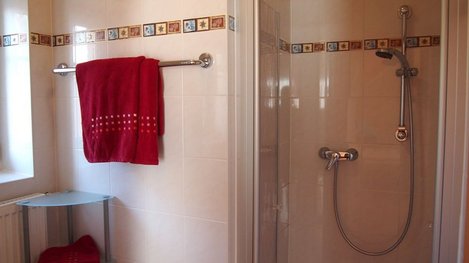 Modernes Badezimmer mit komfortabler Dusche, hellen Fliesen und gepflegter Ausstattung für einen angenehmen Aufenthalt