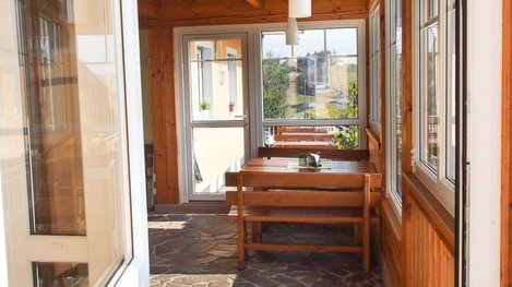 Heller Wintergarten mit gemütlichen Sitzgelegenheiten und viel Tageslicht für entspannte Stunden mit Ausblick