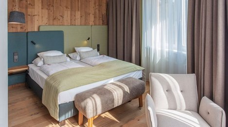 Modern eingerichtetes Hotelzimmer mit Doppelbett und gemütlicher Sitzecke