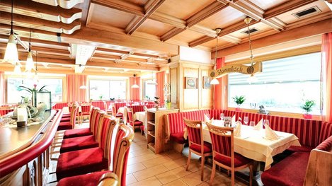Ein gemütliches Restaurant mit traditionellen Holzmöbeln und heller, einladender Atmosphäre lädt zum Verweilen ein