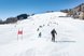 Skifahrer fahren eine verschneite Piste hinunter