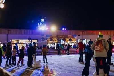 Besucherinnen und Besucher auf der festlich beleuchteten Eislaufbahn