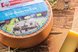Runder Bio-Bauernkäse mit angeschnittener Käsespitze auf einem rustikalen Holztisch präsentiert