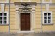 Historisches Eingangsportal mit kunstvoll verziertem Holztor an einer barocken Fassade