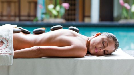 Frau bei einer Hot-Stone-Massage im Wellnessbereich