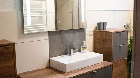 Modernes Badezimmer mit stilvollem Waschtisch, großem Spiegel und freundlicher, heller Ausstattung