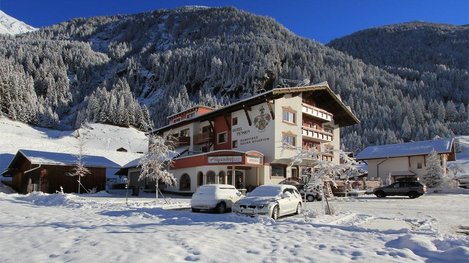 Ein gemütliches Hotel in verschneiter Berglandschaft bietet winterliche Erholung inmitten der Alpen