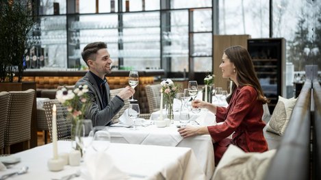Zwei Personen sitzen an einem gedeckten Tisch in einem Restaurant