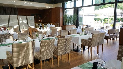 Modernes Restaurant mit großzügigem Speisebereich und stilvoll gedeckten Tischen