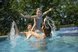 Eine Familie hat Spaß im Schwimmbad und spritzt fröhlich im Wasser