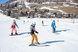 Mehrere Skifahrer fahren eine verschneite Piste hinunter