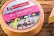 Runder Bio-Mozzarella mit Produktetikett auf einem rustikalen Holztisch präsentiert