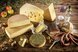 Verschiedene regionale Spezialitäten mit Käsesorten, Wurstwaren und weiteren traditionellen Lebensmitteln auf einem rustikal gedeckten Holztisch