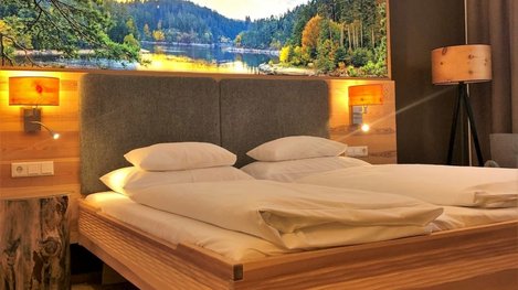 Gemütliches Schlafzimmer mit großem Holzbett und Panoramablick auf die Berglandschaft