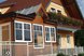 Einladendes Gästehaus mit gepflegter Fassade, verglastem Wintergarten und blumengeschmückten Balkonen in ruhiger Lage