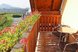 Blumengeschmückter Balkon mit gemütlicher Sitzgelegenheit und herrlichem Panoramablick über die Weinberge und die umliegende Hügellandschaft