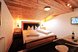 Ein gemütliches Zimmer im alpinen Stil mit Holzmöbeln und komfortablem Doppelbett lädt zum Entspannen und Wohlfühlen ein