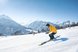 Eine Person fährt auf Skiern durch eine verschneite Berglandschaft